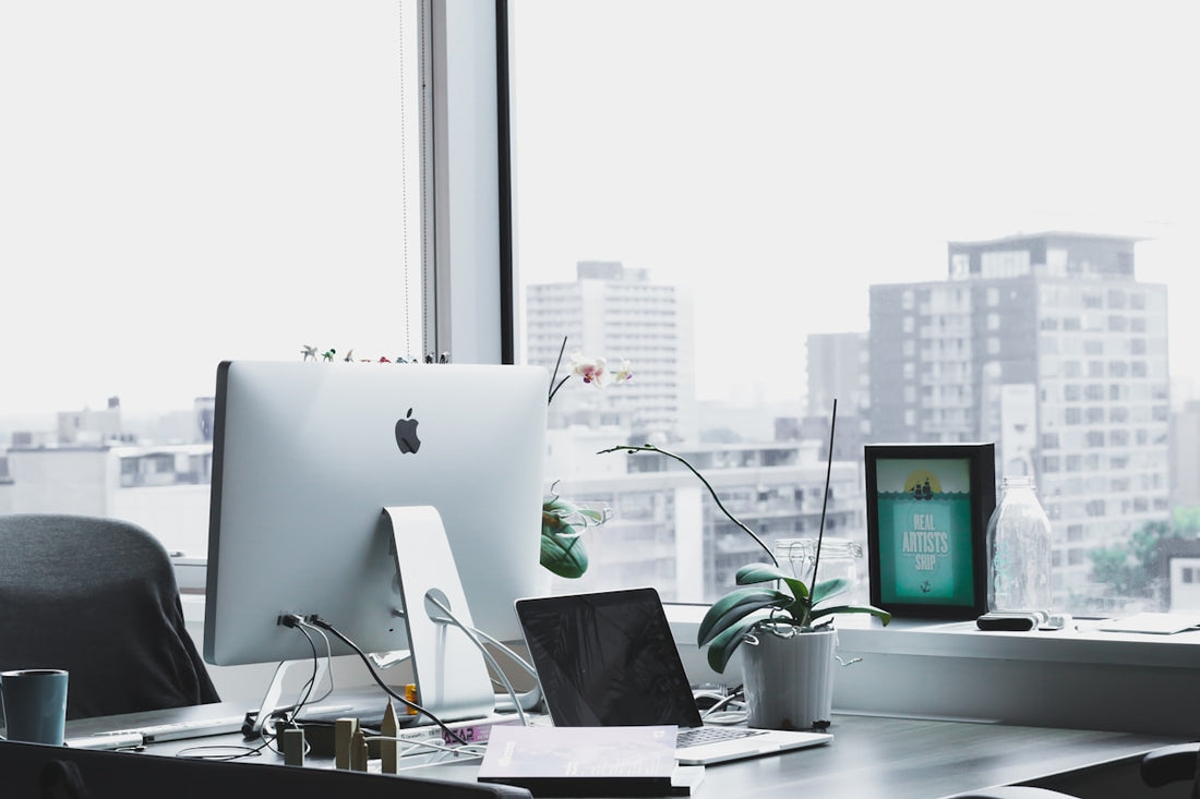 A modern desk with a compact kokedama, showing how it fits clean and productive office setups