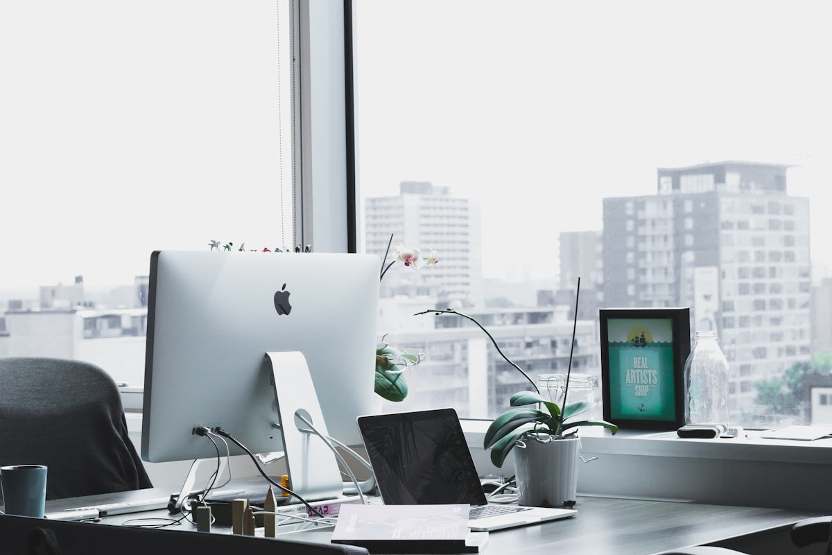A modern desk with a compact kokedama, showing how it fits clean and productive office setups